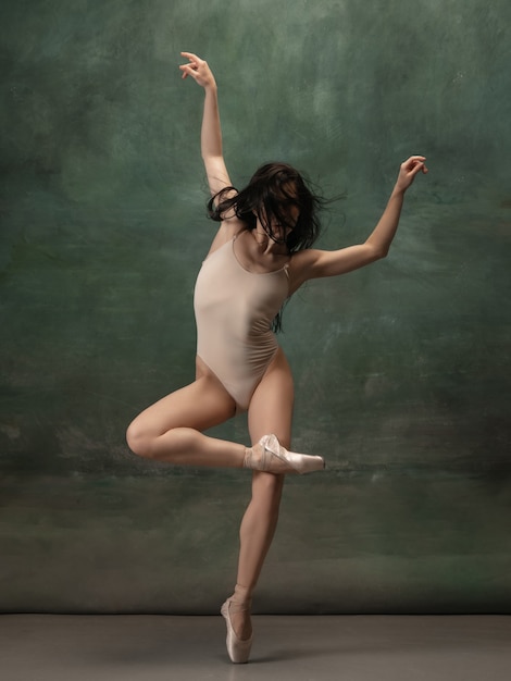 Inspiration. Graceful classic ballerina dancing on dark studio background. Pastel bodysuit. The grace, artist, movement, action and motion concept. Looks weightless, flexible. Fashion, style.