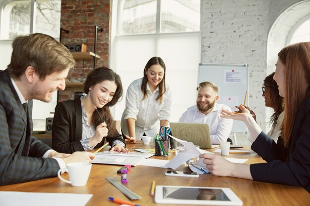 Inspiration. Group of young business professionals having a meeting. Diverse group of coworkers discuss new decisions, plans, results, strategy. Creativity, workplace, business, finance, teamwork.