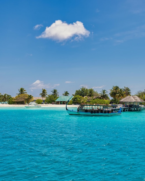 Вдохновляющий дизайн пляжа на Мальдивах. Мальдивская традиционная лодка Дхони и идеальный залив лагуны с голубым морем