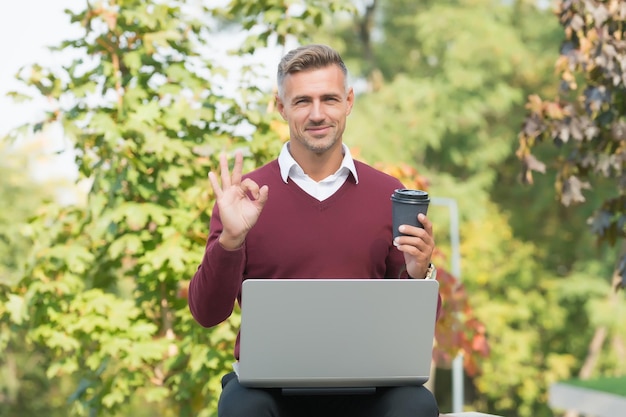 Inspiring drink. Businessman inspired by nature guy feel powerful change world. Man inspired hold laptop. Inspired for start up. Guy with computer in garden. Freelance concept. Perfect morning coffee.