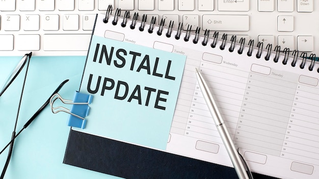 INSTALL UPDATE text on blue sticker on planning and keyboardblue background