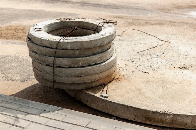 Installatie van betonnen rioolputten in de grond op de bouwplaats. Het gebruik van ringen van gewapend beton voor beerputten, overloop septic tanks. Verbetering van putten en regenwaterafvoer.