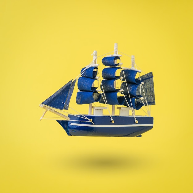 Installatie van een oud schip met zeilen op een gele ondergrond. Een droom die uitkomt.