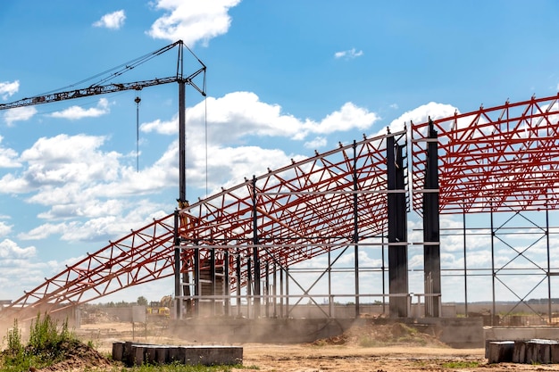 Installatie van metalen spanten en frame tijdens de bouw van een industrieel gebouw of fabriek Het werk van installateurs tijdens de installatie van het dak Bouw van een grote frameshop