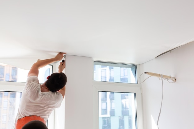 Installatie van spanplafond. Nis voor spanplafond. Spanplafond, werk.