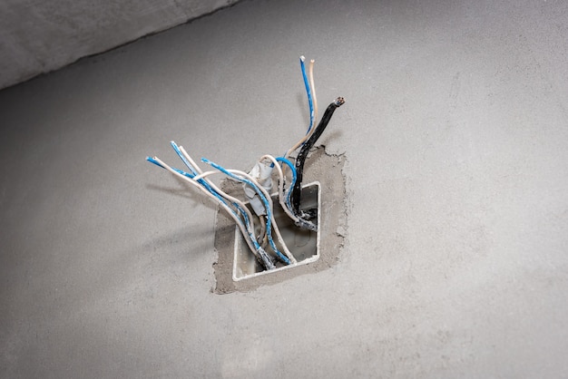 Installation electric box for sockets and wires on concrete wall.