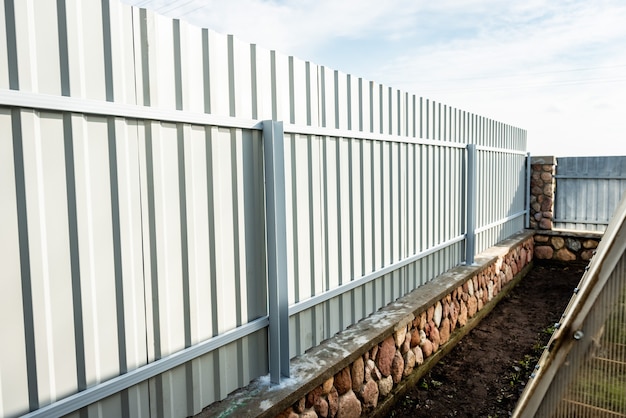 Installation of gray fence from metal profile