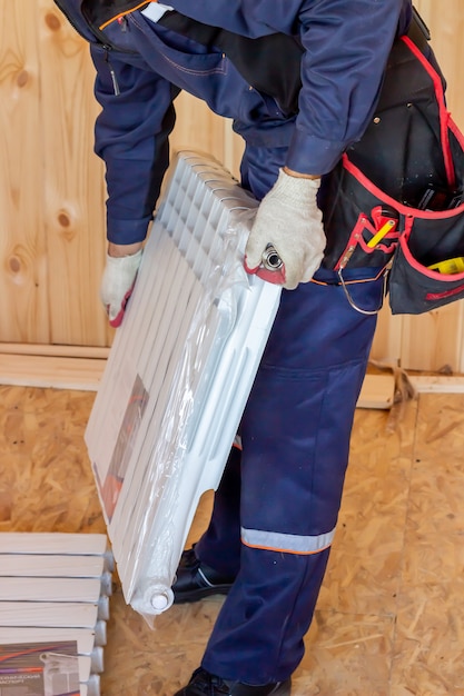 Installation of the heating radiator. Construction of houses and apartments. Builder.