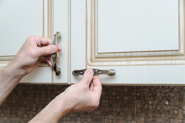 Installation of kitchen furniture and putting handles to door cabinets