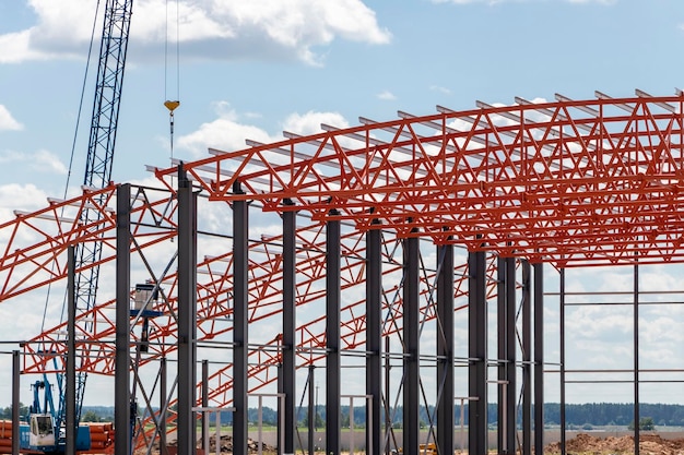 Installation of metal trusses and frame during the construction of an industrial building or factory The work of installers during the installation of the roof Construction of a large frame shop