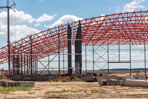 Installation of metal trusses and frame during the construction of an industrial building or factory The work of installers during the installation of the roof Construction of a large frame shop