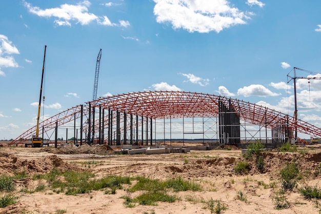 Installation of metal trusses and frame during the construction\
of an industrial building or factory the work of installers during\
the installation of the roof construction of a large frame\
shop