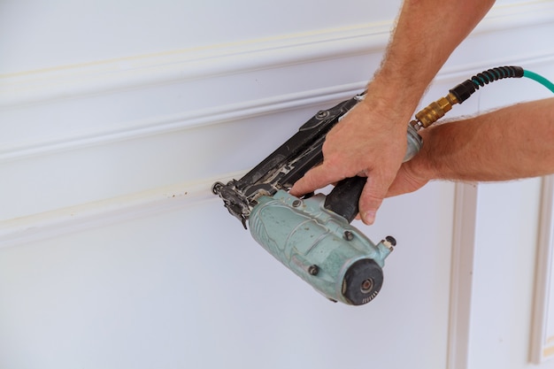 Installation of mouldings on the wall of the refurbished room. 