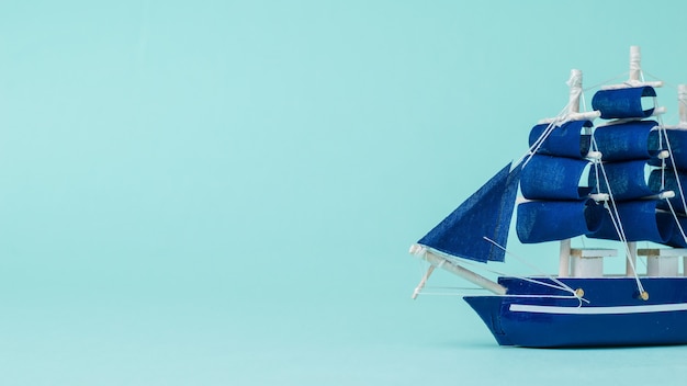 Installation of a sailboat floating on the side on a blue surface. The concept of travel and adventure.