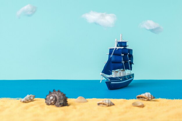 Installation of a sailboat moored to a sandy beach with seashells. The concept of travel and adventure. Installation.