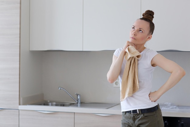 Installed kitchen in a new apartment and  young housewife in front.