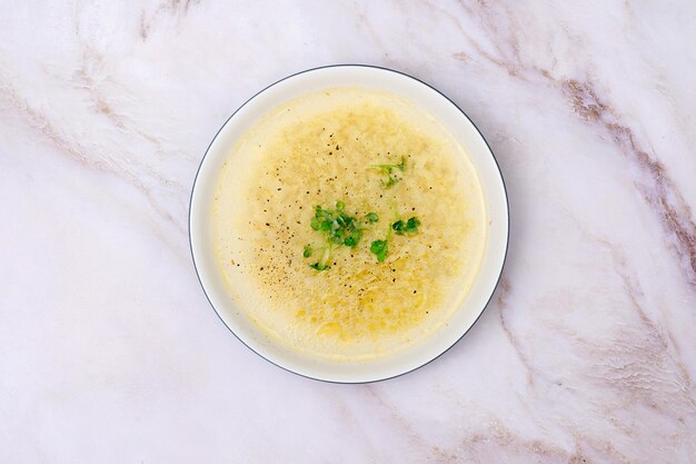 Photo instant chicken bone noodle soup in a white ceramic bowl isolated on white marble background parsley