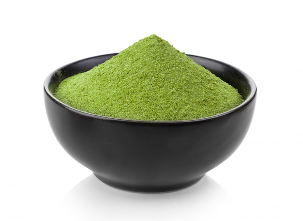 Instant matcha green tea in black bowl on white