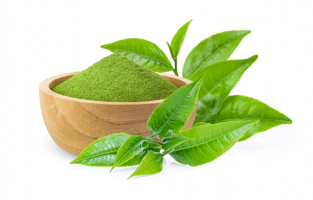Растворимый зеленый чай в деревянной миске с листьями на белом