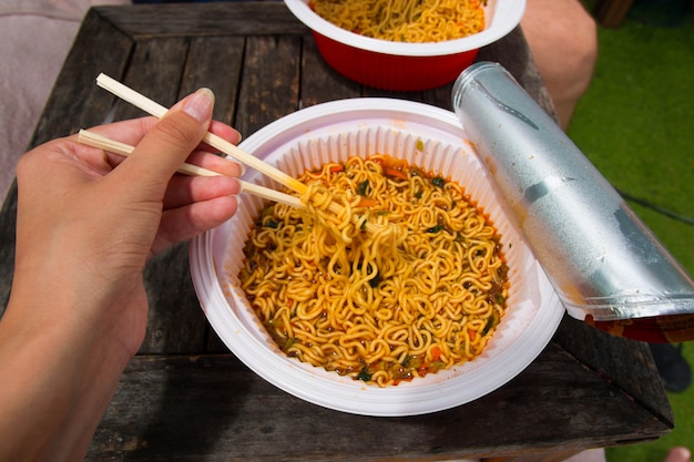 Instant noodle and hand with food sticks