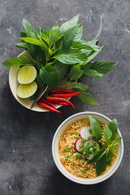 Instant noodles in bowl with fresh herbs, garnish of cilantro and Asian basil