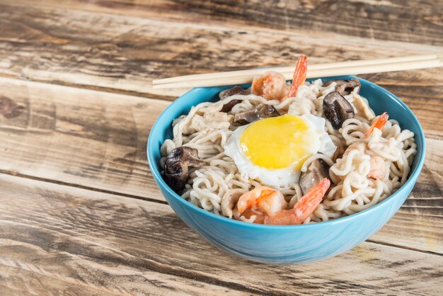 Instant noodles soup with shrimps, egg and mushrooms.