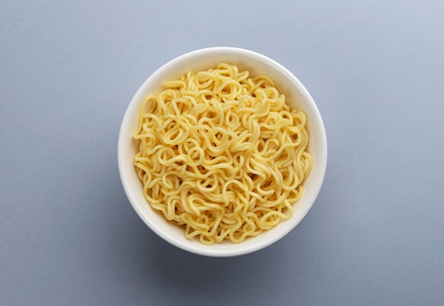 Instant noodles in white plate with copy space, top view