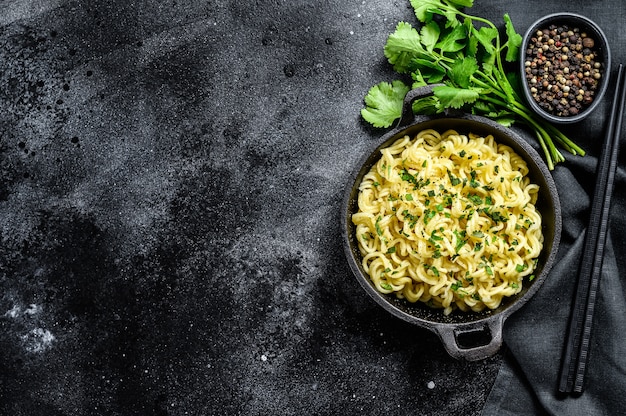 Instant noodles with coriander in an iron pot