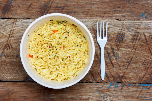 Instant noodles on wooden background, top view close-up