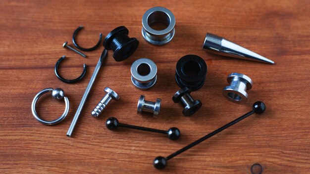 Instellen voor piercing Accessoires voor piercings op houten achtergrond.