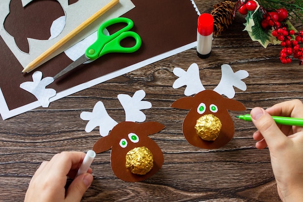 Instruction step 10 Funny Gift with candy Christmas deer on a wooden table Handmade