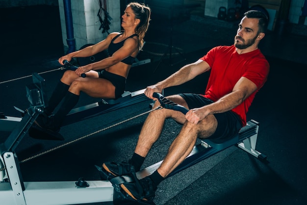 Instructor exercising with woman at gym
