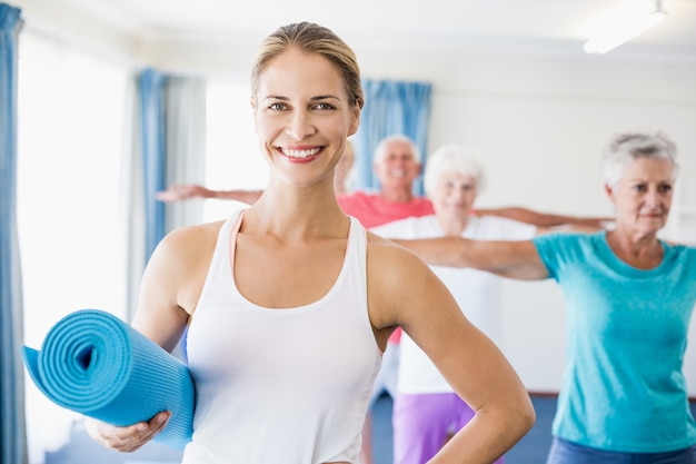 Instructor holding yoga mat