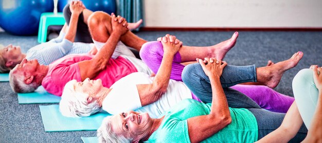 Инструктор, выполняющий йогу с пожилыми людьми