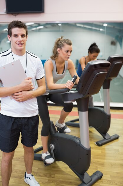 Instructor at spinning class with two women