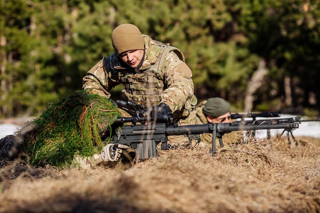 Instructor with operator aiming machine gun at firing range People and military concept