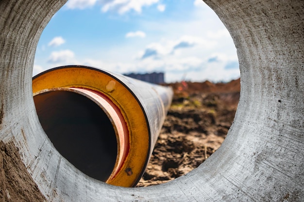 Tubo isolato tubi metallici di grandi dimensioni con guaina di plastica in un cantiere tubazioni moderne per la fornitura di acqua calda e riscaldamento in un'area residenziale primo piano