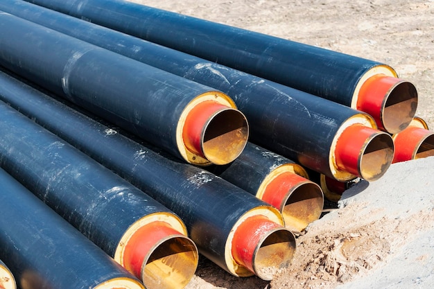 Insulated pipe Large metal pipes with a plastic sheath at a construction site Modern pipeline for supplying hot water and heating to a residential area