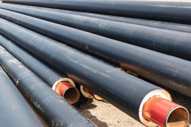 Insulated pipe Large metal pipes with a plastic sheath at a construction site Modern pipeline for supplying hot water and heating to a residential area