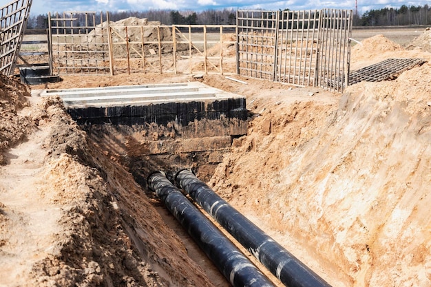 Insulated pipe Large metal pipes with a plastic sheath laid in a trench Modern pipeline for supplying hot water and heating to a residential area