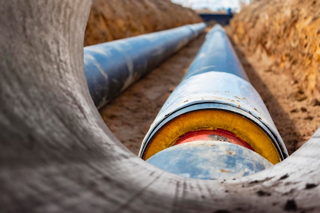 Photo insulated pipe large metal pipes with a plastic sheath laid in a trench modern pipeline for supplying hot water and heating to a residential area