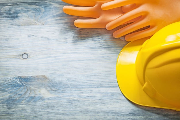 Insulating gloves hard hat on wooden board electricity concept.