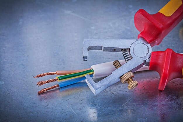 Insulation strippers electric wires on metallic background horizontal view electricity concept