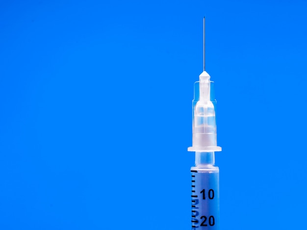 Insulin syringe closeup on blue table. diabetes