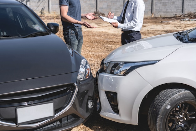 L'agente assicurativo che esamina l'incidente d'auto e il cliente hanno valutato la negoziazione, il controllo e la firma sul processo del modulo di richiesta del rapporto dopo la collisione, incidente e concetto di assicurazione