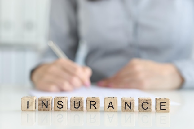 Insurance agent fills out insurance form in office medical and home insurance concept