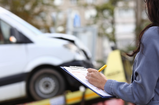 Photo insurance agent fills out paperwork after accident.