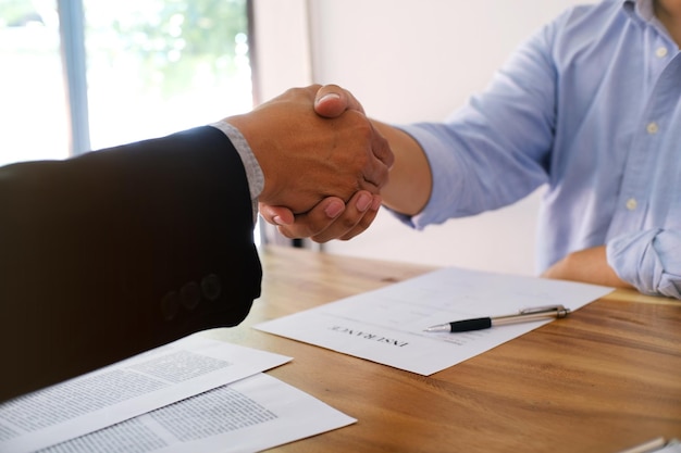 Foto l'agente assicurativo stringe la mano al cliente