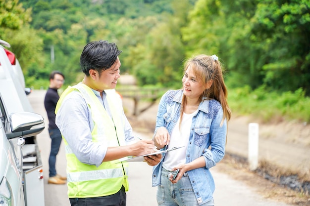 The insurance company officers ask the female driver about an accident to write a report