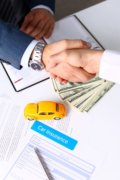 Insurance form lying on table with yellow toy car